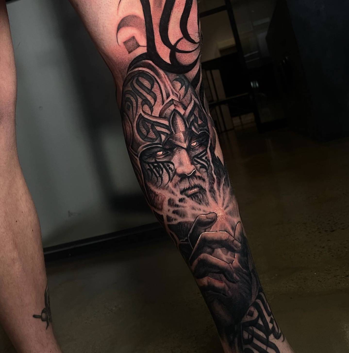 Upper arm and shoulder tattoo with abstract curved patterns and geometric elements